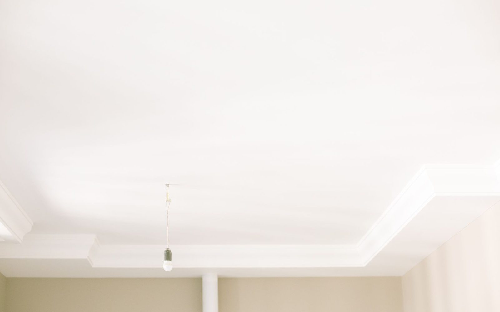 Flat white painted ceiling with plain coving and a pendant light