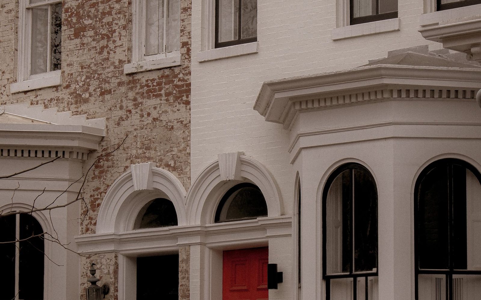 White painted frontage of a period terraced house with bay windows